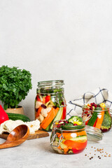Fermented vegetables in glass jars. Fermented preserved vegetarian food. Homemade canned food concept. Various pickled vegetables.