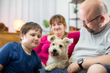 A typical family picture with a dog during an evening of relaxation and rest.