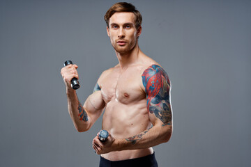 Fototapeta na wymiar athletic man with dumbbells in the hands of a workout