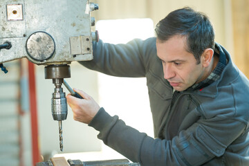 a workman using bench drill