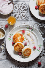 Breakfast with cheese cakes and natural yogurt, top view, selective focus