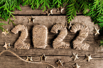 Handmade numbers 2022 from rope on an old wooden table top view. Festive composition for Christmas and New Year made from natural materials.