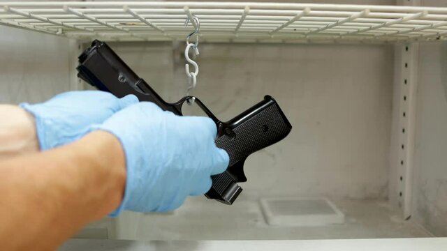 csi police, revealing fingerprints on a gun in a Cyanoacrylate fuming chamber