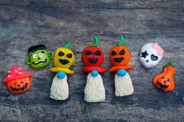 Naklejka premium Figures of three dwarfs decorated with a pumpkin. There are Halloween decorations nearby.