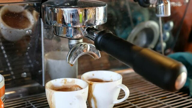 Grinder expresso with large coffee maker pouring on cup