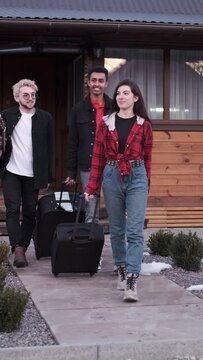 Young woman and men with suitcases leaving home