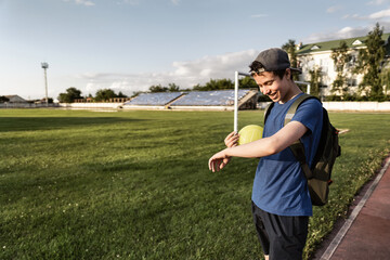 concept of sports and health - teen boy posing at a stadium, a soccer field with green grass.