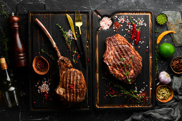 Set of grilled veal steaks on a black background, top view