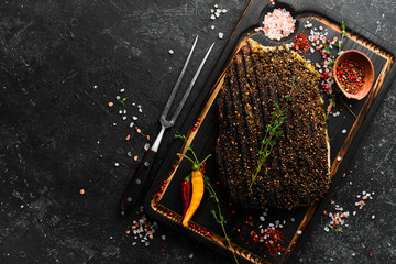 Veal steak. Juicy pepper steak cooked on the grill on a black background, top view