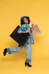 Young black woman laughing while walking with shopping bags
