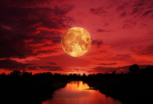 blood moon concept of a red full moon in black sky with cloud.