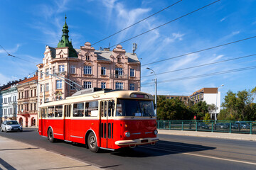 Fototapeta na wymiar Red omnibus runs through the Pilsen city centre, Czech republic