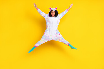Fototapeta na wymiar Full length photo of young afro woman happy positive smile jump up nightwear playful isolated over yellow color background