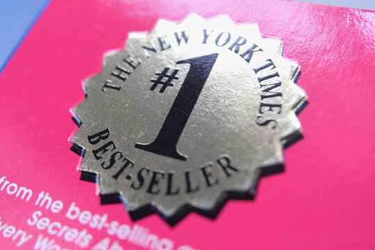 The Label 'The New York Times #1 Best-seller' On The Front Cover Of A Bestselling Book. Macro Closeup View. Book Listed Number One On NYT Bestseller Ranking.