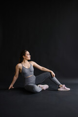 Fototapeta na wymiar Confident pose of fitness trainer portrait. Woman in sportswear. Strong beautiful sportswoman with make-up. The owner of the gym. Lifestyle. Sportive curvy girl with a muscular figure. Healthy 