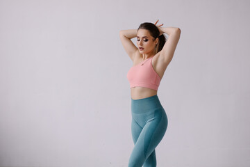 Obraz premium Confident pose of fitness trainer portrait. Fashion woman in sportswear. Strong beautiful sportswoman with make-up. Lifestyle. Sportive curvy sensual girl with a muscular figure. Healthy gym workout