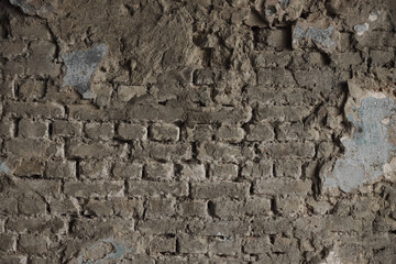 Structure of old stone damaged ancient brick wall and plaster for texture background closeup.