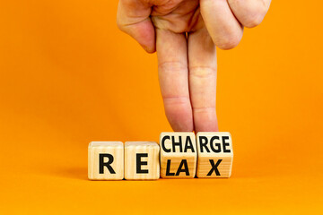 Relax and recharge symbol. Businessman turns cubes and changes the word 'relax' to 'recharge'....