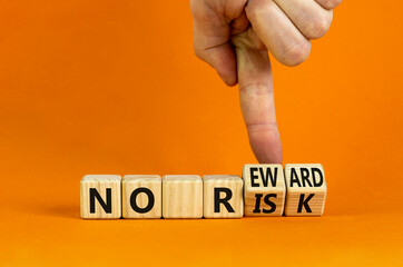 No risk and reward symbol. Businessman turns wooden cubes and changes words 'no risk' to 'no reward'. Beautiful orange background. No risk and reward, business concept. Copy space.