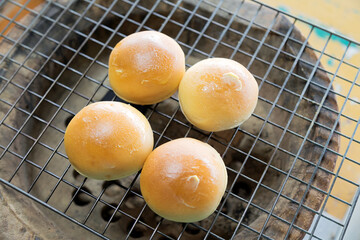 The buttered toast is placed on the grill and used in the charcoal oven for heating. smells delicious