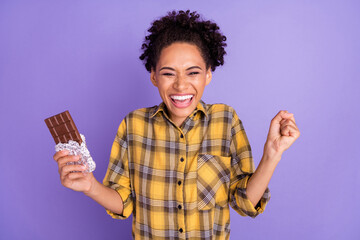 Photo of young african girl happy positive smile eat chocolate yummy diet isolated over purple color background