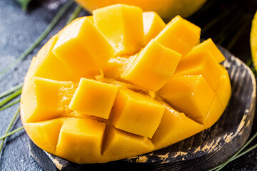 Juicy orange mango in a cut on a wooden board