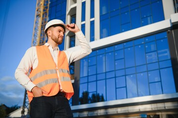 A construction worker control a pouring concrete pump on construction site and sunset background