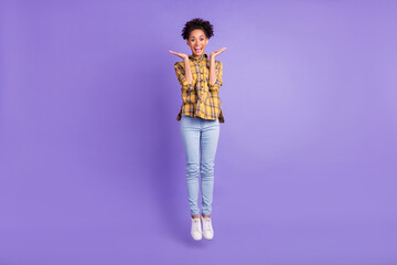 Full length photo of young african girl happy positive smile jump up excited news isolated over purple color background