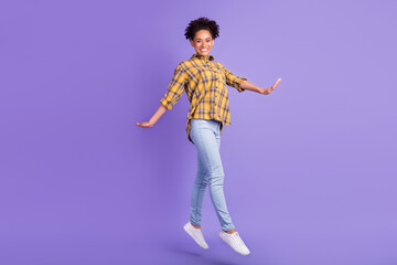 Full size profile side photo of young afro girl happy positive smile jump step isolated over purple color background