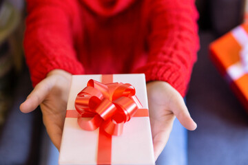Hands of a woman giving a Christmas present