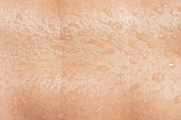 wet female skin texture with liquid drops close-up. tanned human body with water drops.