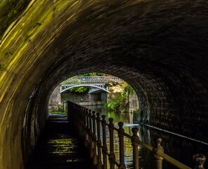 looking through a tunnel to the old Victorian bridge over the Kennet and Avon canal in Sydney Gardens Bath Somerset England