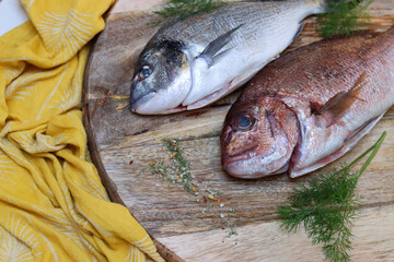 Fresh fish on wooden cutting board. Uncooked Dorada Fish on a table. Healthy eating concept. 
