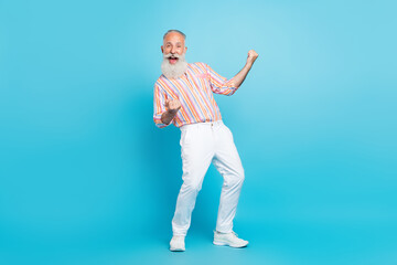 Full size photo of aged man happy positive smile rejoice victory ecstatic lottery isolated over blue color background