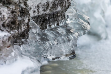 Icicles and frost on a snow-covered frozen river