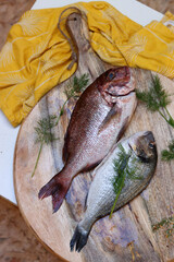 Fresh fish on wooden cutting board. Uncooked Dorada Fish on a table. Healthy eating concept. 