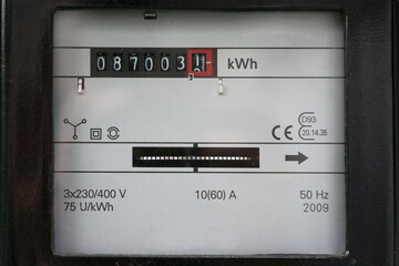 Electricity meter counting kilowatt hours consumed at home, concept of saving money on power...