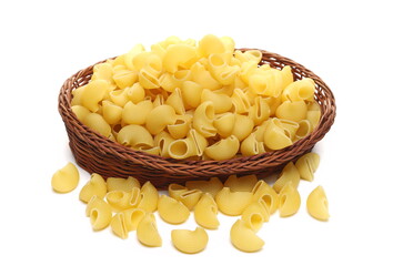 Pasta lumaconi rigati pile in wooden wicker basket isolated on white background