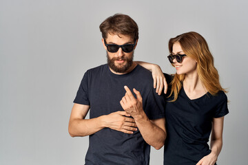 fashionable man and woman in black t-shirt sunglasses posing isolated background