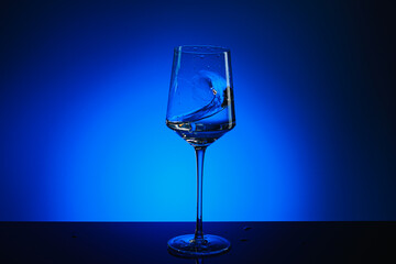 Splash of water in a glass on a blue background.