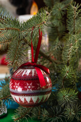Christmas balls with a pattern on the branch of a Christmas tree close-up.