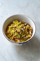 Oatmeal Porridge with Milk Jam, Walnut and Pistachio Powder.