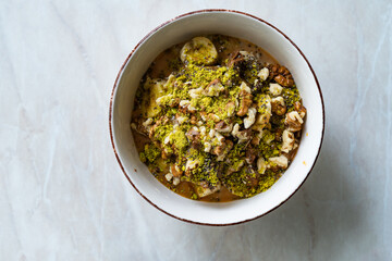Oatmeal Porridge with Milk Jam, Walnut and Pistachio Powder.