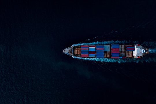 containers ship corgo logistic transportation sailing top speed in dark sea Photograph aerial top view from drone point view at night process