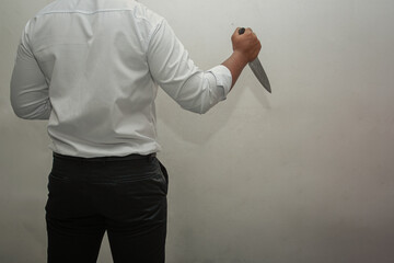 Knife killer. A man in a white shirt and black pants holding a knife. white background