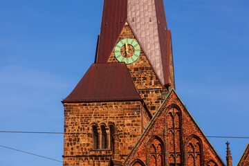 the clock of the church Unser Lieben Frauen (church of Our Lady) in Bremen (Germany) shows 11.59 h in bright sunshine in front of blue sky