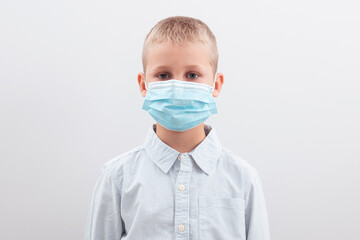 Portrait of an upset boy wearing a medical mask