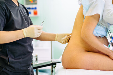 Close up of unrecognizable male doctor injecting Epidural Anesthesia for pregnancy Labor during...