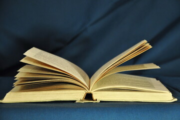 An open old book on a blue background