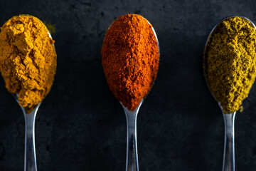 A set of spicy oriental spices on a black background, for Asian cuisine recipes.
